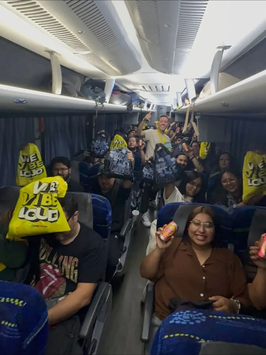 Camión del tour lleno de viajeros con las bolsas amarillas del Kit Conecta
